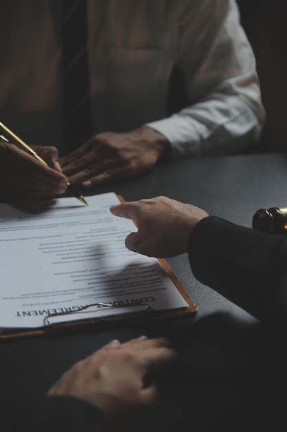 Business and lawyers discussing contract papers with brass scale on desk in office Law legal services advice justice and law concept picture with film grain effect