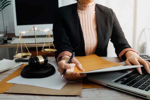 Business and lawyers discussing contract papers with brass scale on desk in office Law legal services advice justice and law concept picture with film grain effect