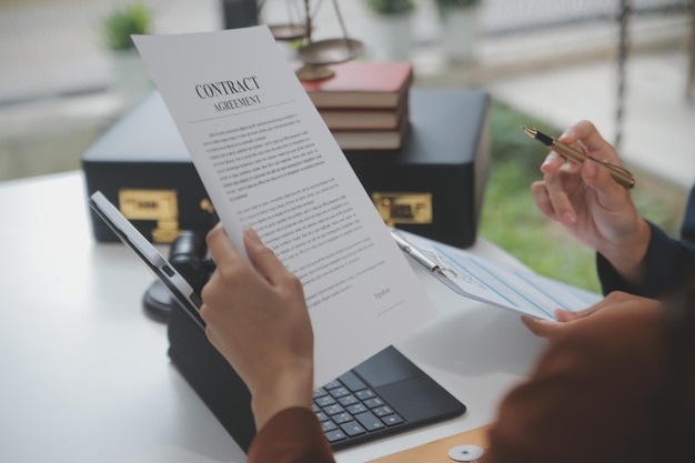 Business and lawyers discussing contract papers with brass scale on desk in office Law legal services advice justice and law concept picture with film grain effect