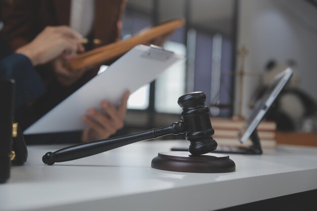 Business and lawyers discussing contract papers with brass scale on desk in office Law legal services advice justice and law concept picture with film grain effect