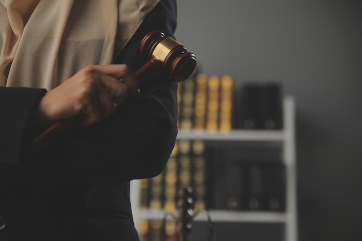 Photo オフィスの机の上で真ちゅう製の目盛り付きの契約書について話し合うビジネスと弁護士