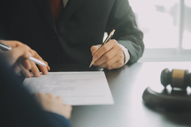 Business and lawyers discussing contract papers with brass scale on desk in office Law legal services advice justice and law concept picture with film grain effect