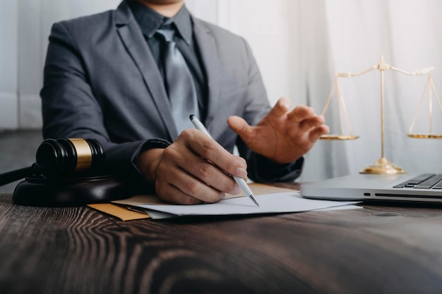 business and lawyers discussing contract papers with brass scale on desk in office law legal services advice justice and law concept picture with film grain effect