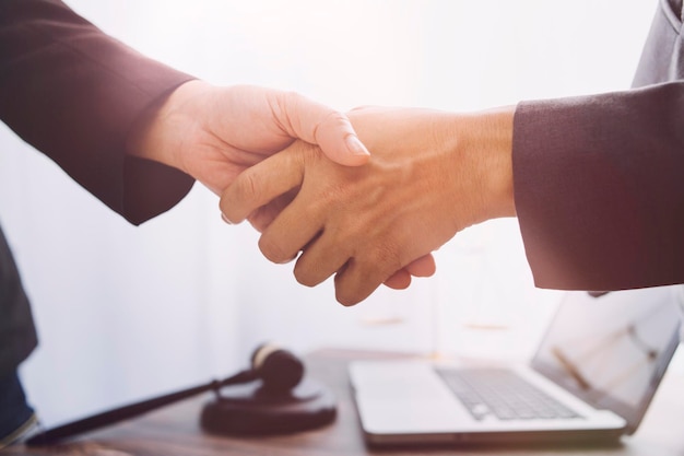 Business and lawyers discussing contract papers with brass scale on desk in office Law legal services advice justice and law concept picture with film grain effect