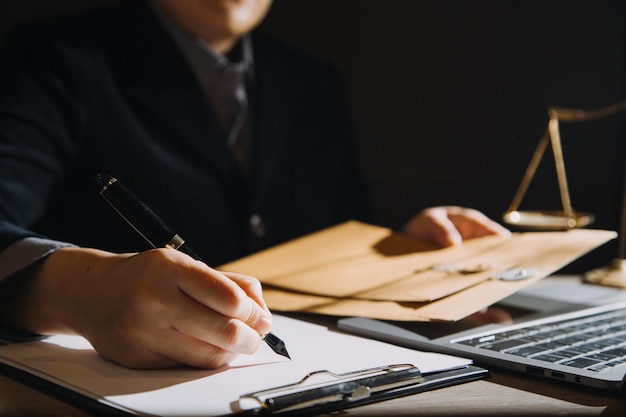 Business and lawyers discussing contract papers with brass scale on desk in office Law legal services advice justice and law concept