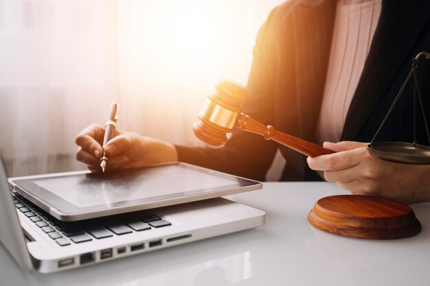 Business and lawyers discussing contract papers with brass scale on desk in office Law legal services advice justice and law concept