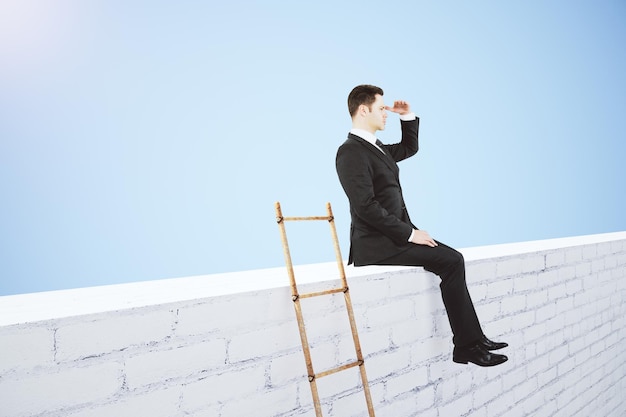 Business leader concept with white brick wal wooden stairway and businessman looking into the distance