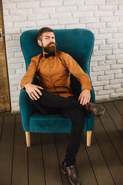 Business leader and thought leader on a turquoise chair on the\
terrace