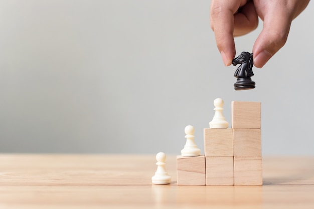 Business leadership concept with chess on top wood block ladder staircase