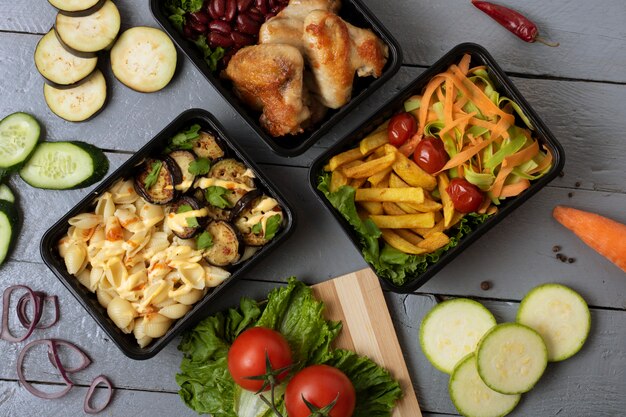 Business lunch in food boxes, roast chicken wings, steamed vegetables, stewed meat, ready meal to eat