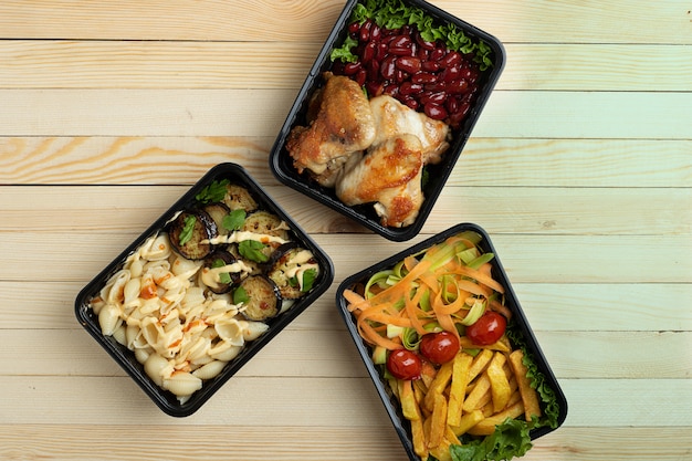 Business lunch in food boxes, roast chicken wings, steamed vegetables, stewed meat, ready meal to eat