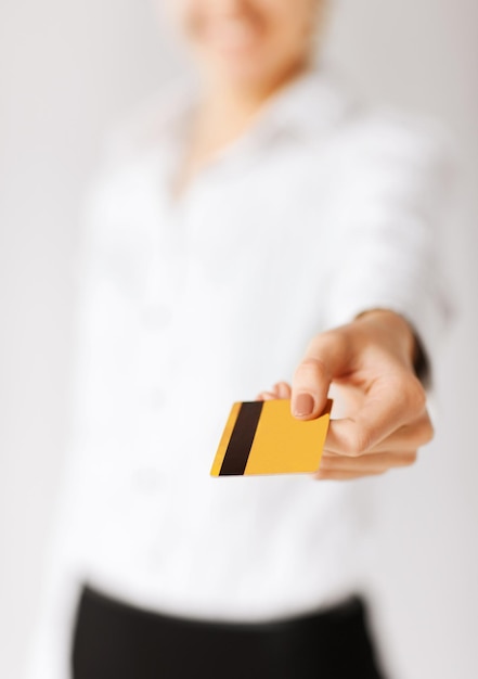 business, luxury, shopping and money concept - woman showing gold credit card