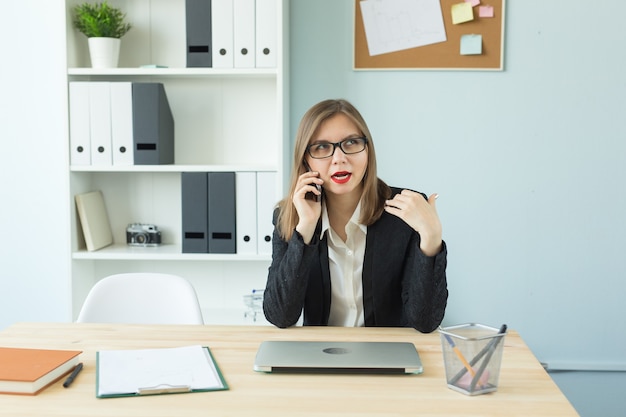 Business, makelaar en mensen concept - aantrekkelijke vrouw met rode lippen in kantoor praten over de telefoon
