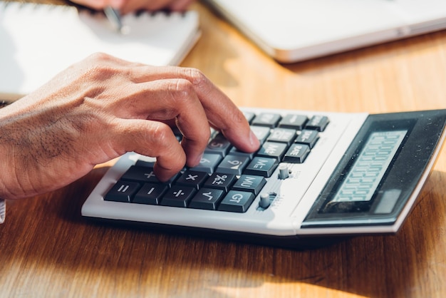 Business man accounting using calculating and work with laptop computer on desk office, finance concept