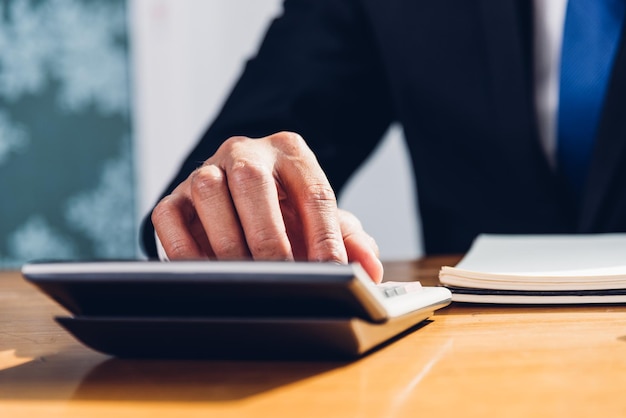 Business man accounting using calculating and work with laptop computer on desk office, finance concept