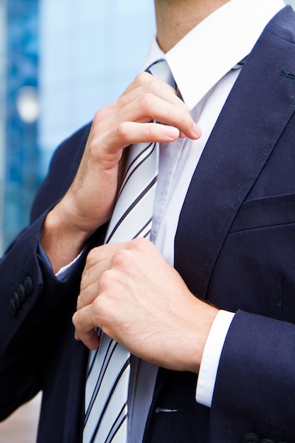 Business man adjusting tie