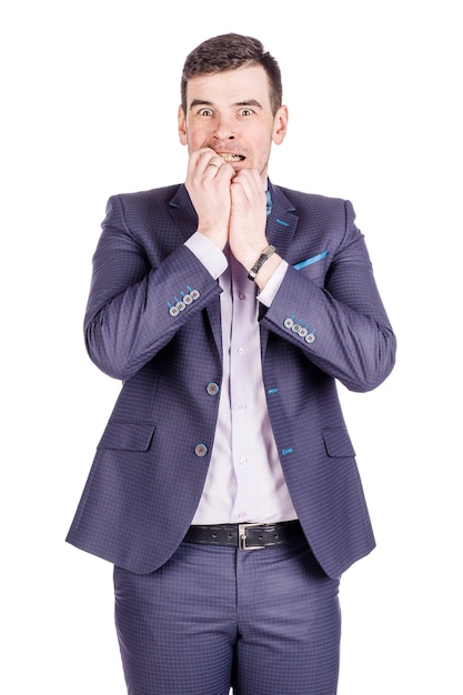 Business man biting his nails fingers freaking out human emotion expression and lifestyle concept image on a white studio backgroundxA