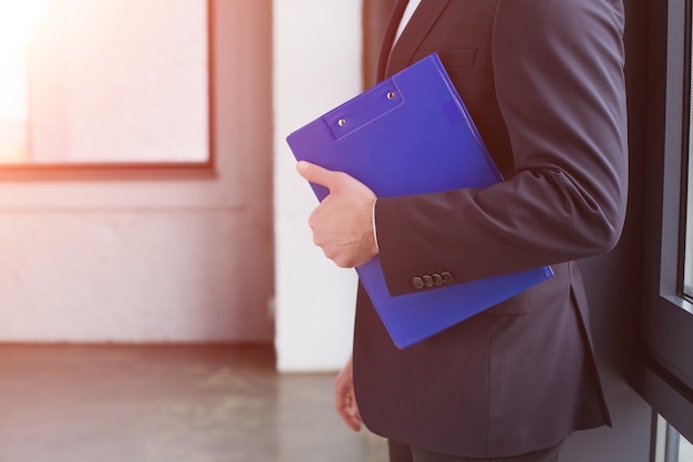 Business man in a black suit holding a clipboard