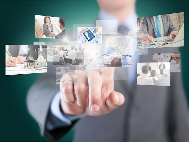 Business man in black suit touching screen with signs on background