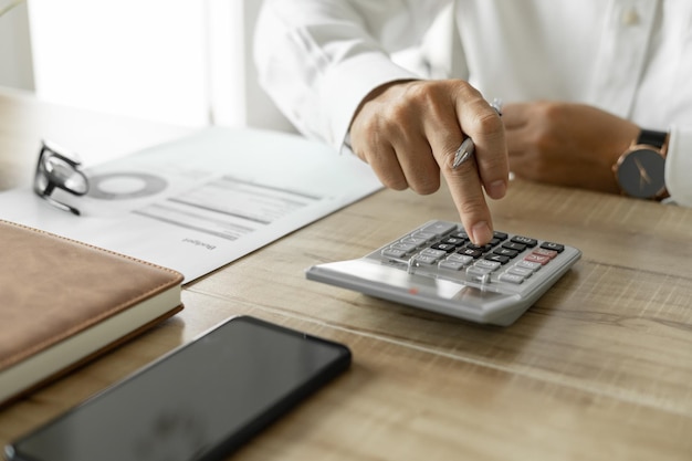 Business man calculating business investment man in white shirt working on desk in office