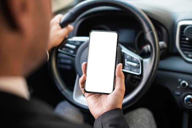 Business man in the car looking at mobile phone