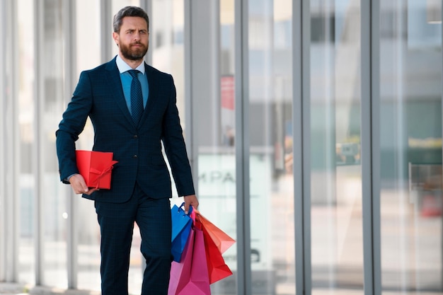 Business man carrying shopping bags walking in city
