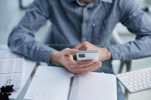 Photo business man ceo wearing sitting in office using cell phone solutions