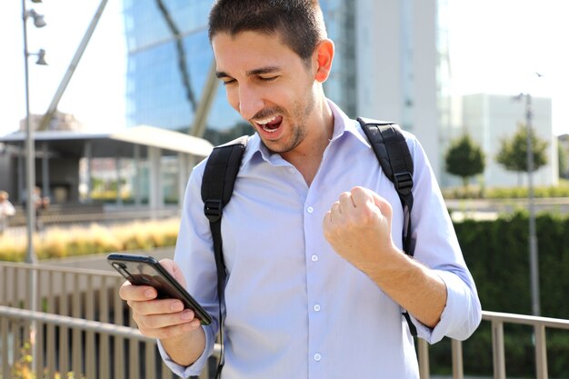 Business man checking good news on smartphone