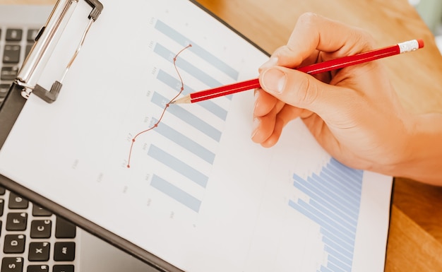 Photo business man checks information in charts in office near laptop