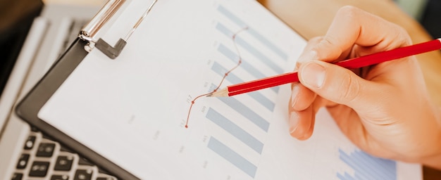 Business man checks information in charts in office near laptop