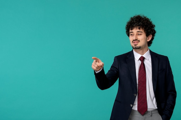 Business man curly cute handsome guy in black suit and red tie pointing front and smiling