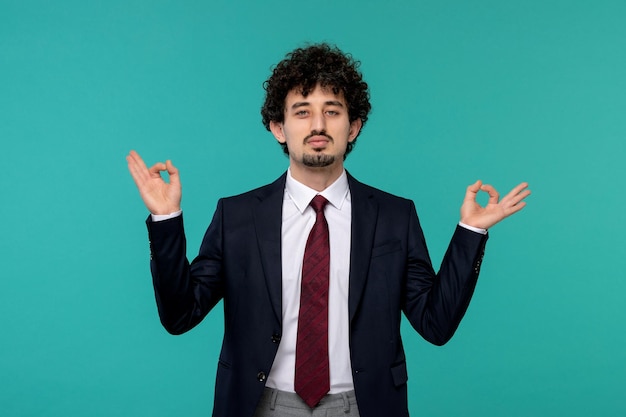 Business man curly cute handsome guy in black suit showing zen gesture sign