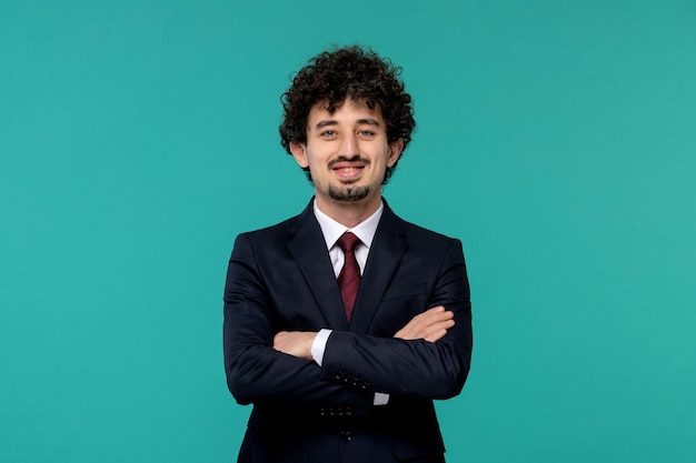 Business man curly cute handsome guy in black suit with crossed hands smiling