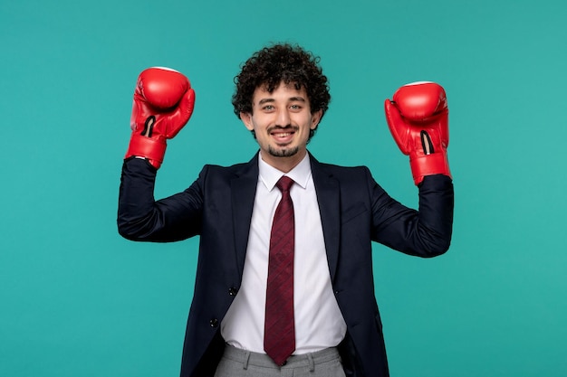 Uomo d'affari riccio carino bel ragazzo in abito nero con guanti da boxe rossi