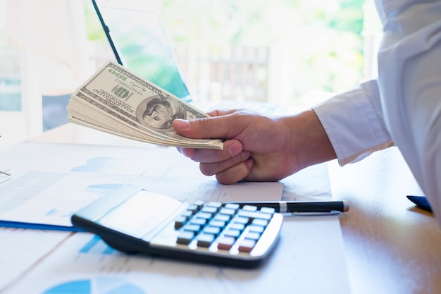 Business Man Displaying a Spread of Cash on office desk