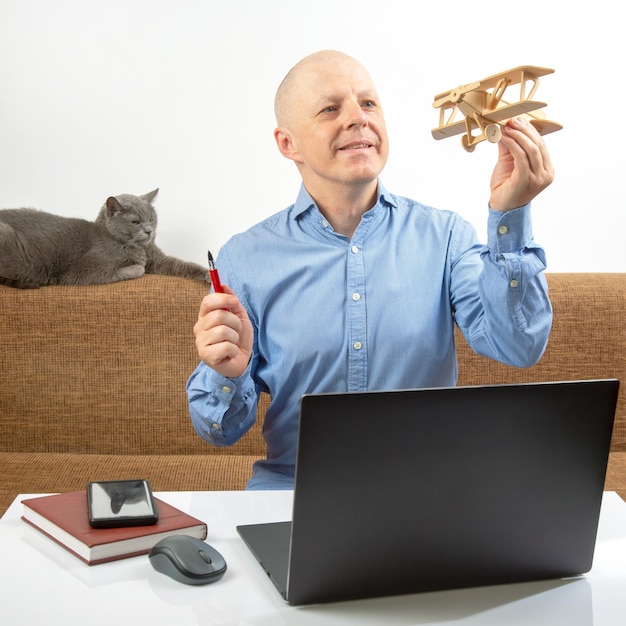 Business man dreams of his achievement Business dream concept A man holds a wooden airplane model in his hands