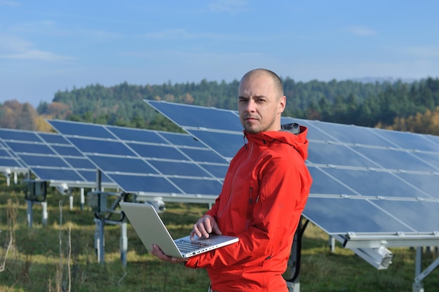 business man  engineer using laptop at solar panels plant eco energy field  in background