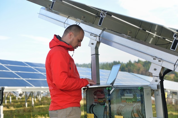 business man  engineer using laptop at solar panels plant eco energy field  in background