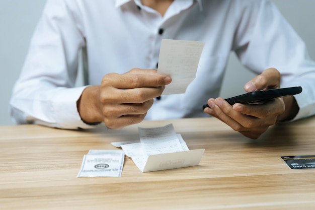 Photo business man entering password code on mobile phone paying bill with credit card bill on desk in home office, internet, digital marketing, mobile banking, online payment and digital technology concept