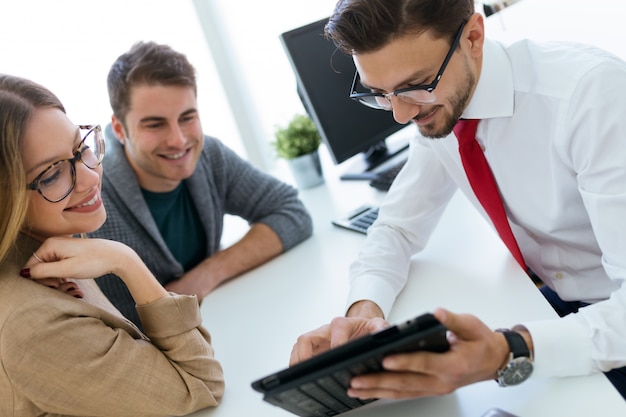 Business man explaining terms of contract to his clients in the office.