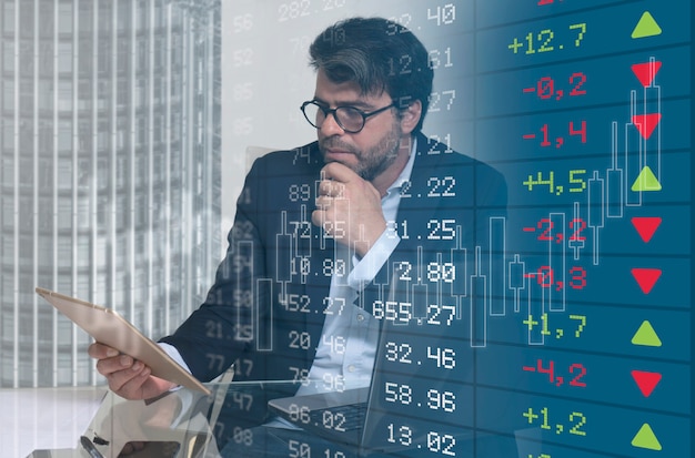 business man following the evolution of stock market graphs on the tablet selective focus