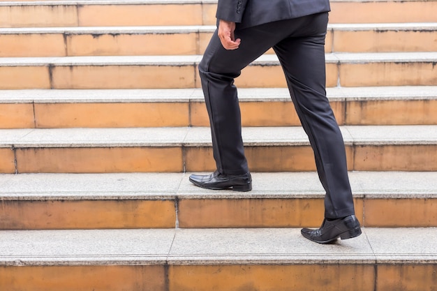 Uomo di affari che sale le scale in un'ora di punta per lavorare. affrettati.