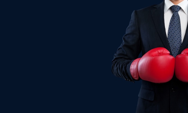 Business man in grey suit with red boxing gloves