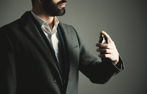 Business man hand holding bottle of perfume