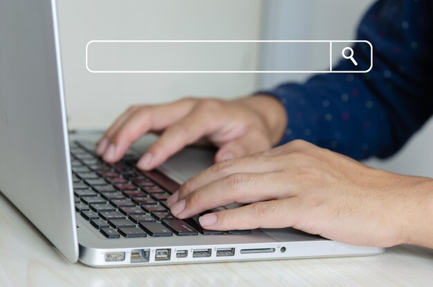 Photo business man hand using a laptop keyboard is searching for information on the internet social networks