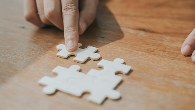 Photo business man hands connecting jigsaw puzzle business solutions success and strategy concept