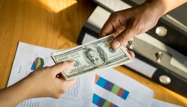 Business man hands handing money over a business dealing