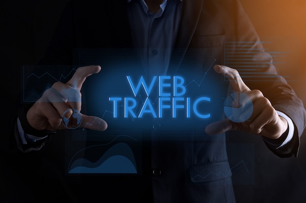 Business man hands holding inscription WEB TRAFFIC with different graphs.successful business concept.Website traffic improvement.SEO.