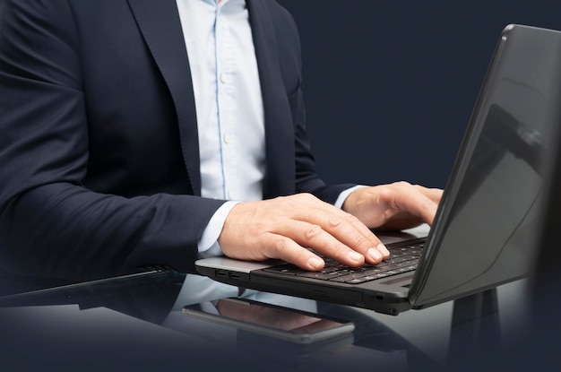 Business man at his desk working on the computer - focus on hands