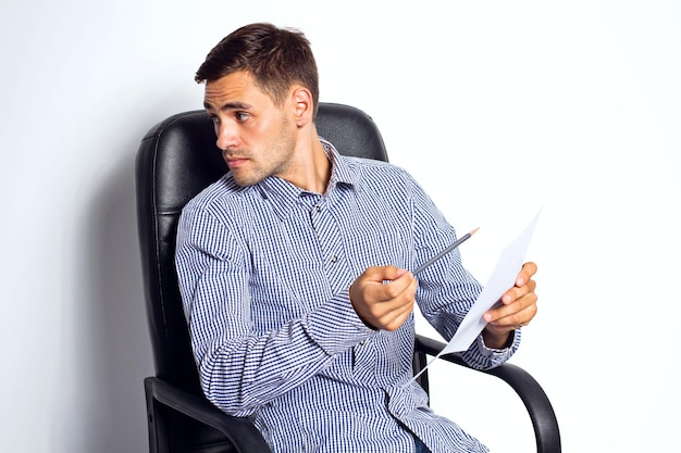 Деловой человек держит бумагу и маркер в офисе на белом фоне